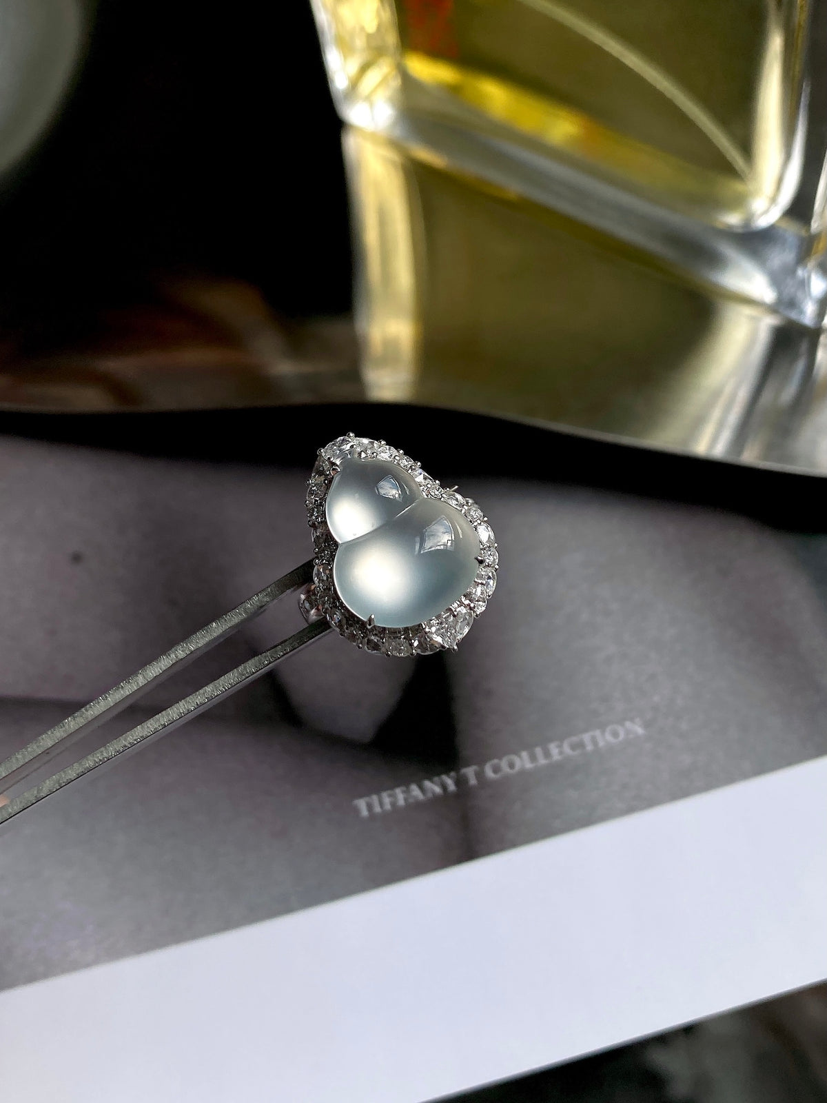 Oval white jade cabochon ring with detailed halo and slim silver band