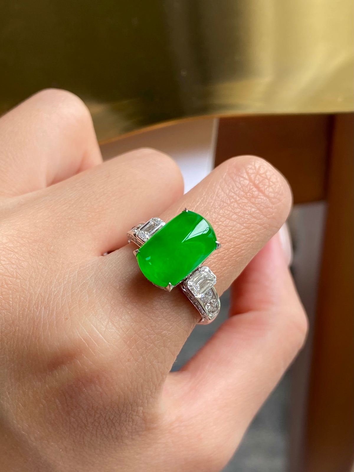 Green jadeite tablet ring close-up showing silver prongs and diamond accents