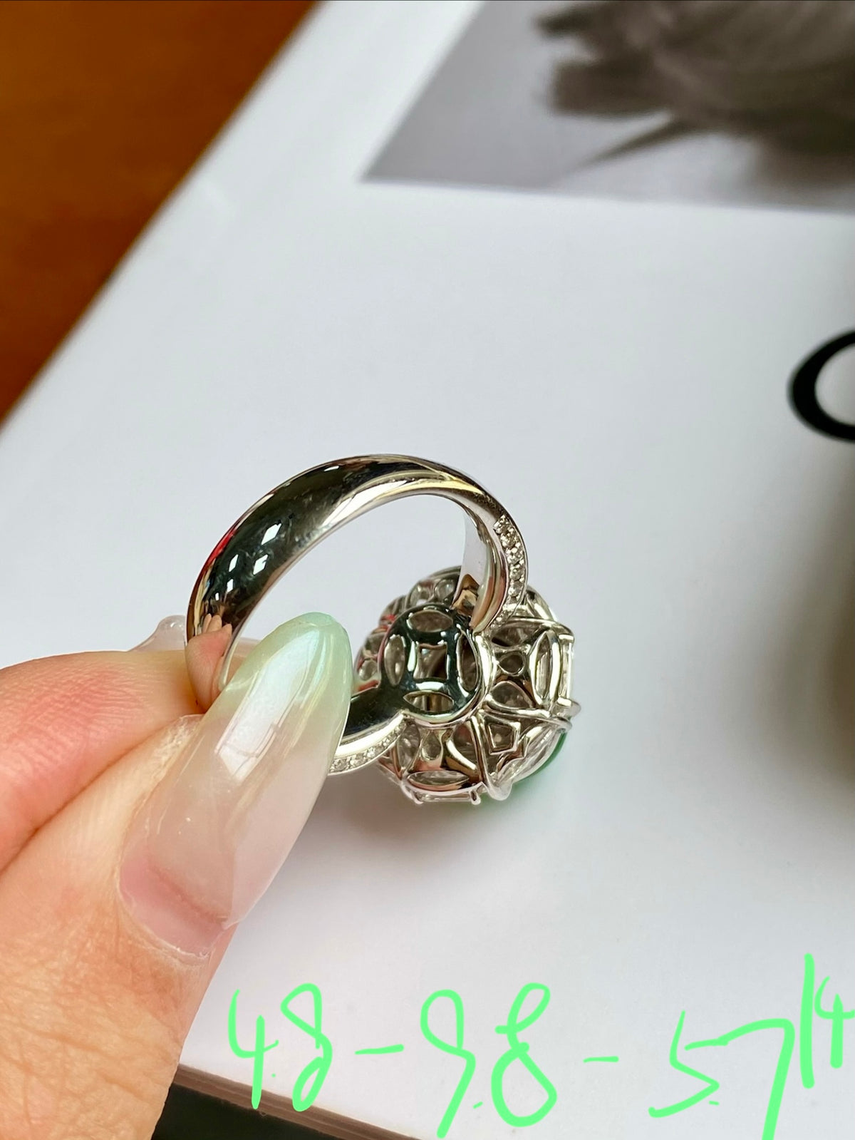 Side profile of green jade cabochon ring with ornate prongs and band
