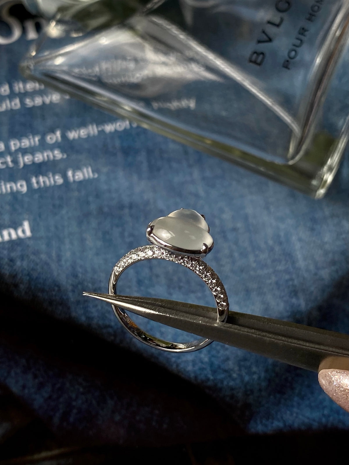 White jadeite gourd ring with pavé band, held by tweezers