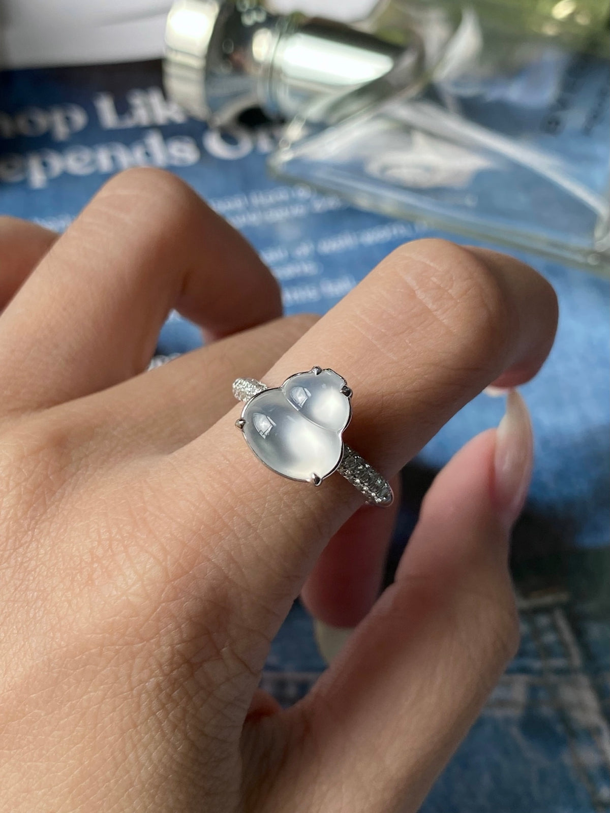 Silver-tone ring with light gray-white cabochon, worn on finger