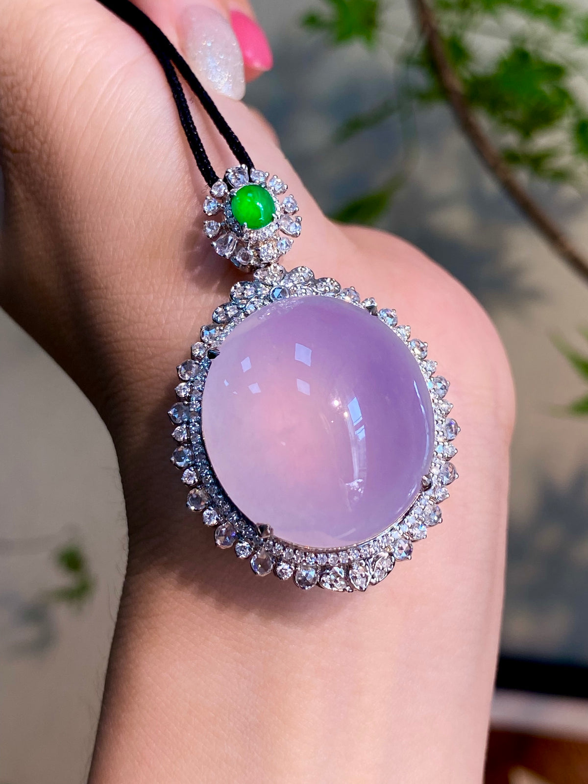 Lavender oval jade-style pendant with green top stone and sparkling halo on black cord