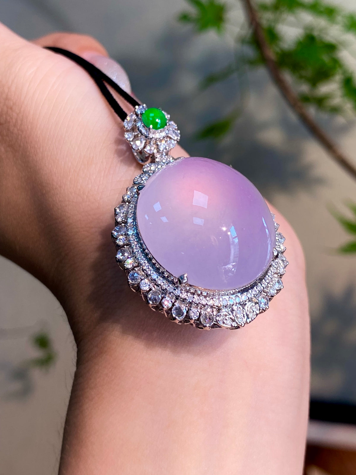 Lavender oval cabochon pendant on black cord, green stone top and diamond halo