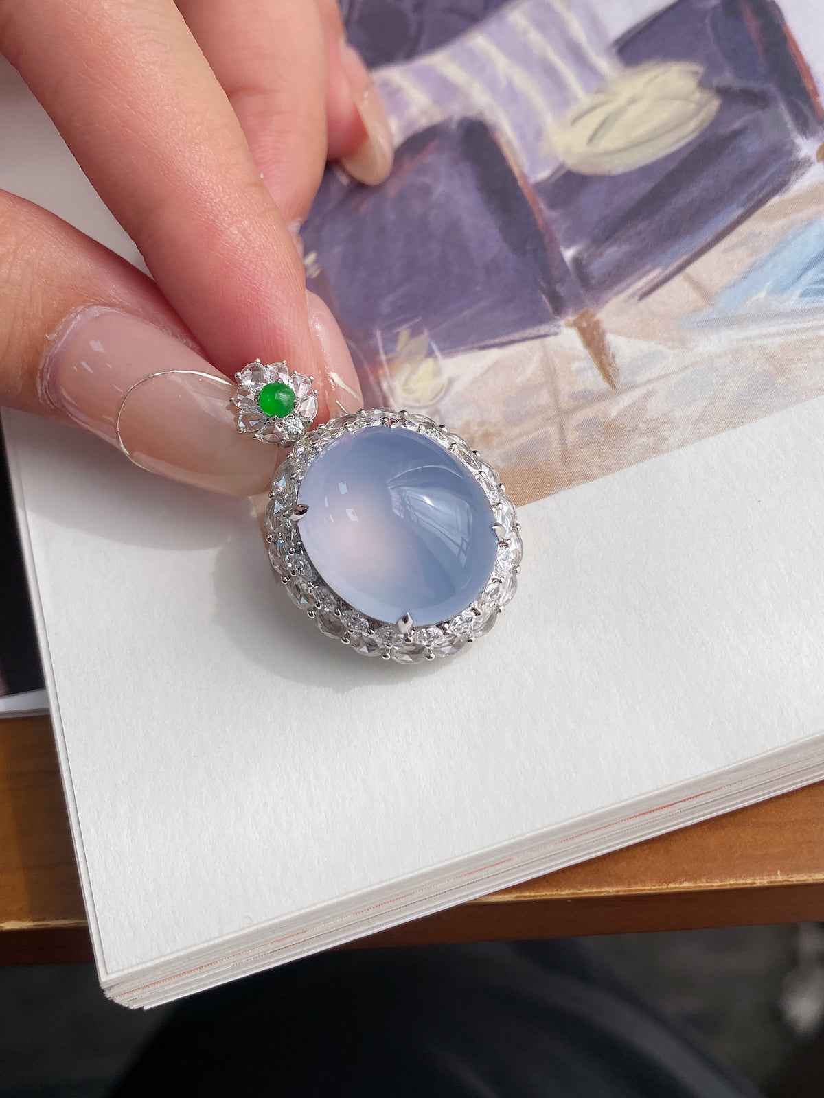 Oval light blue cabochon pendant with silver-tone halo and green flower top