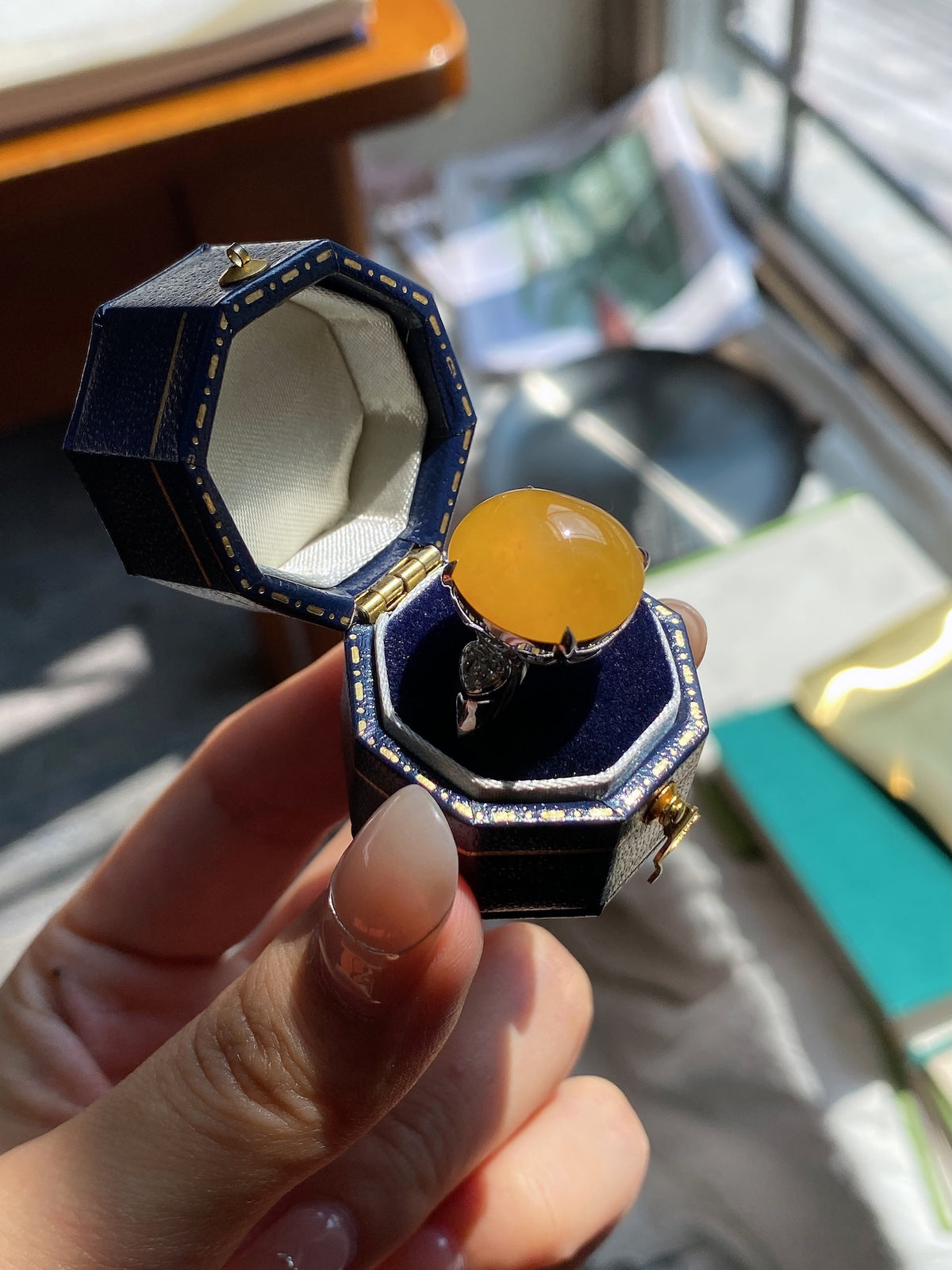 Jadeite cabochon ring, golden yellow oval stone with dark blue octagonal setting