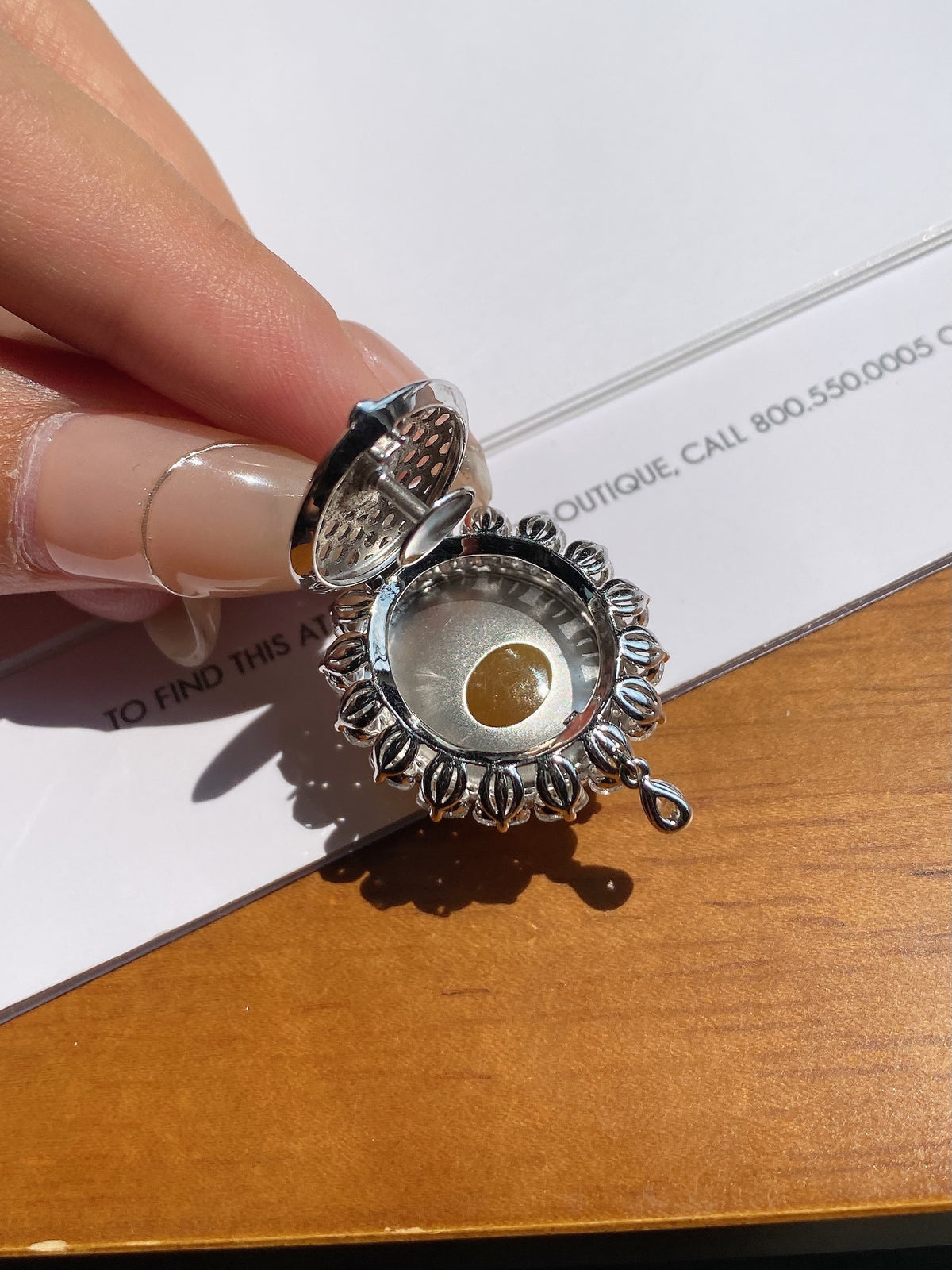 Silver-toned pendant bail and reverse side with round yellow cabochon center