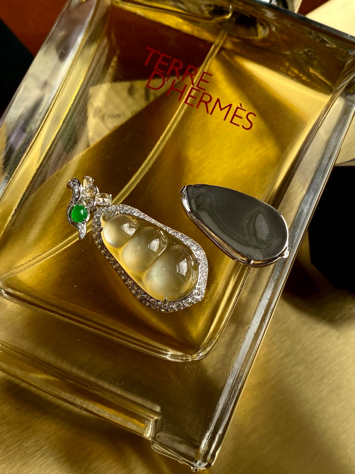 Silver teardrop jadeite pendant with green accent gem and halo of stones