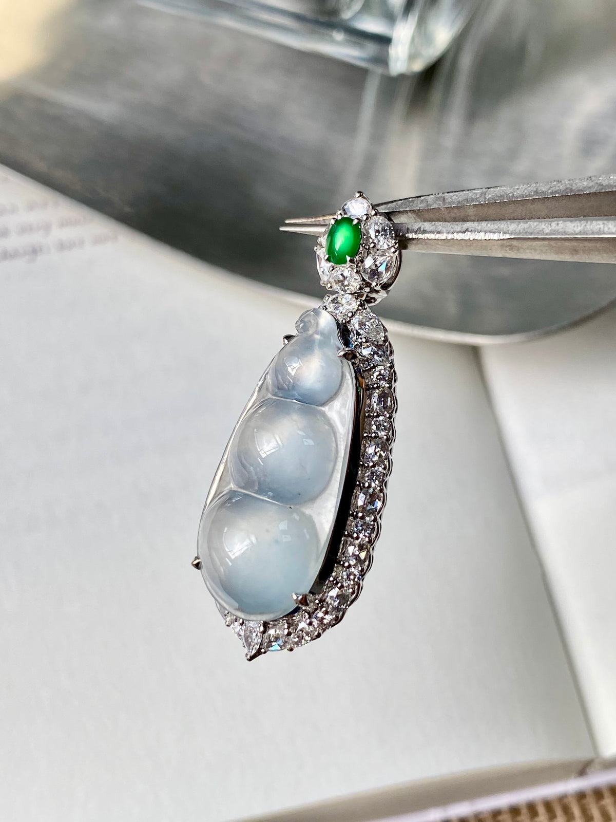 White ice jadeite bean pendant with silver setting and green accent stone