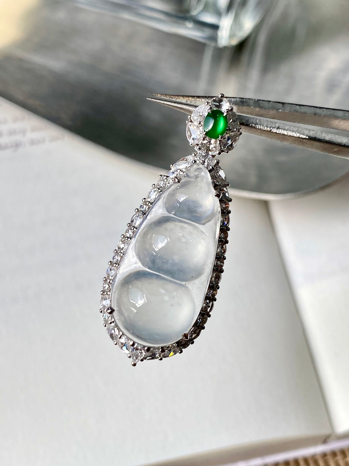 White-ice jadeite bean pendant with silver-tone pavé setting and green accent