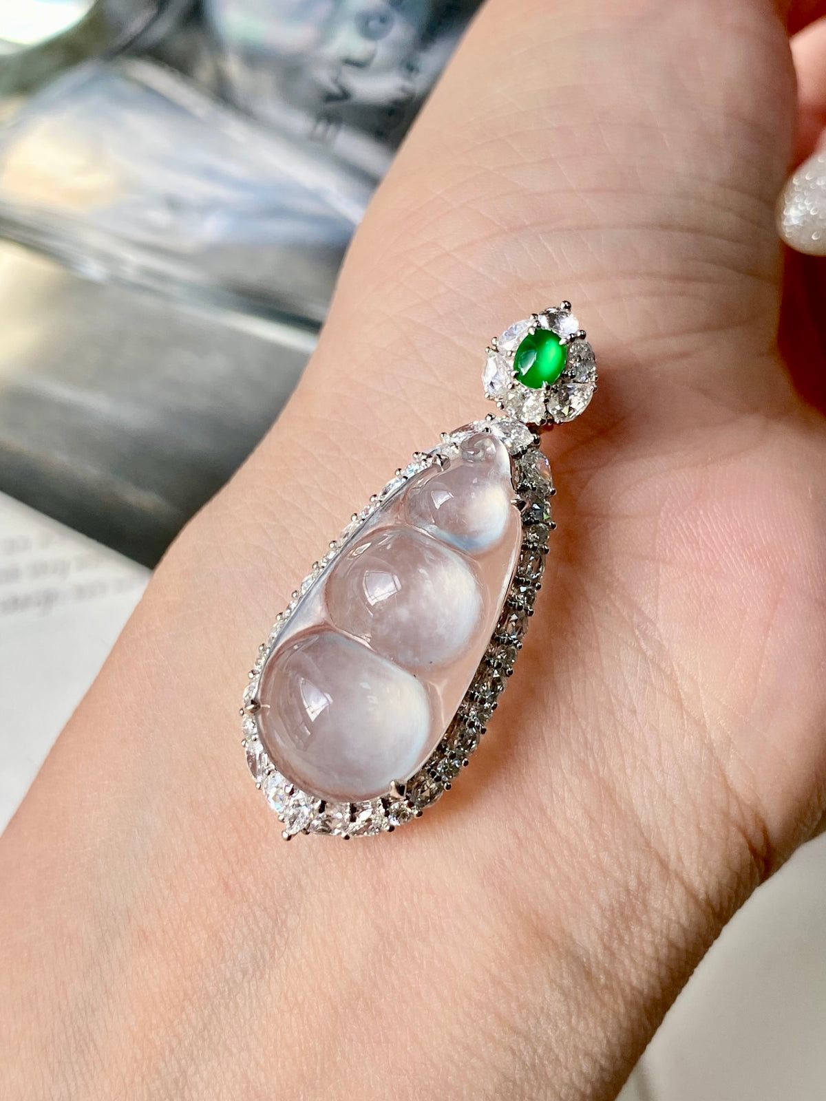 White jadeite bean pendant with silver setting and green accent stone
