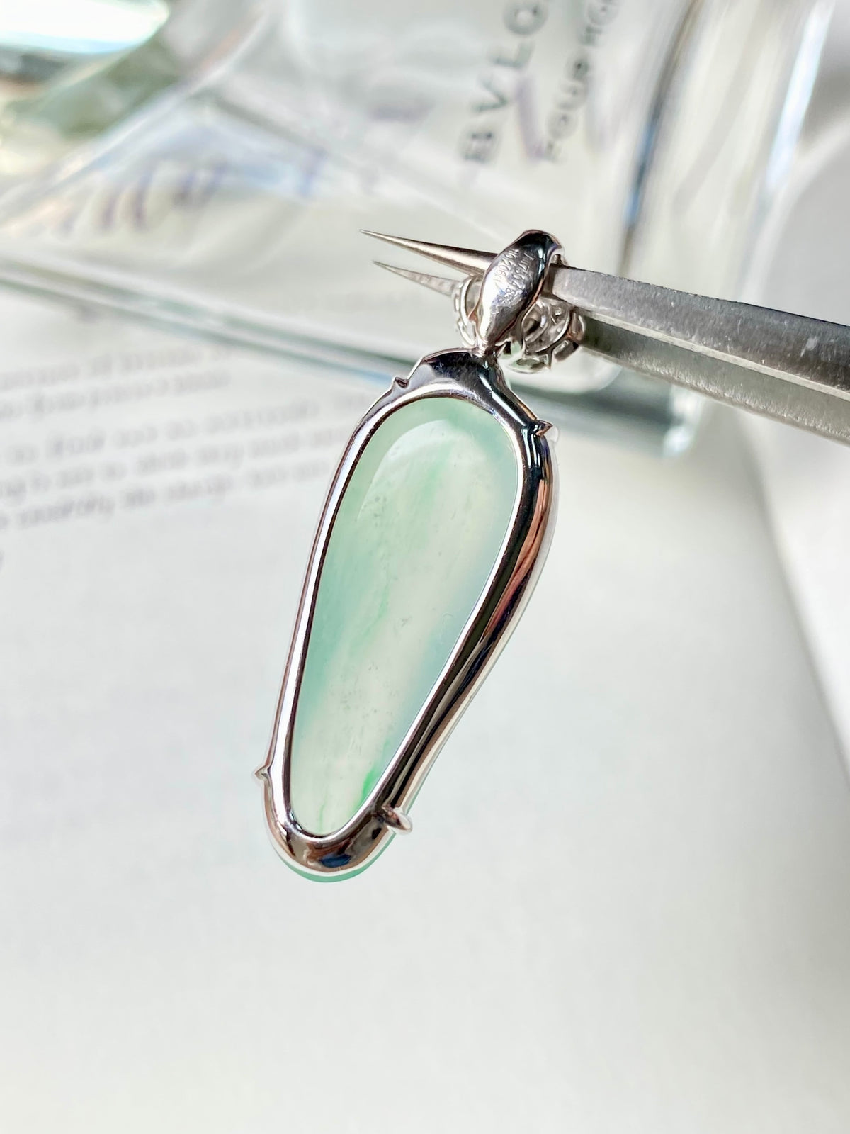 Jadeite gourd pendant side view with small round green stone, silver frame