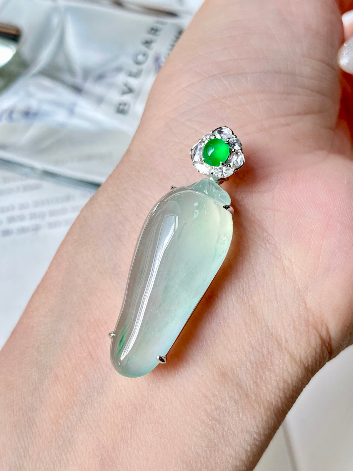 Jadeite gourd pendant on hand: glossy green drop with round green top and halo