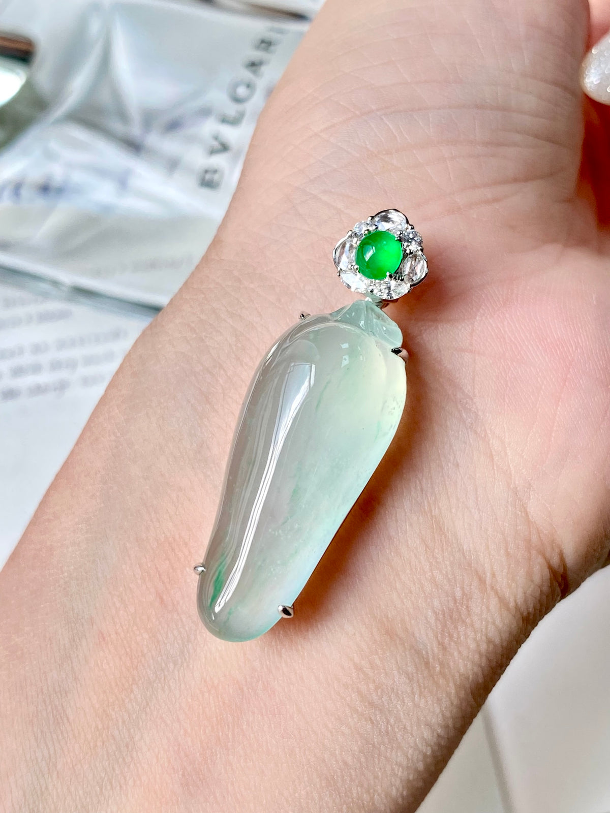 Close-up jadeite gourd pendant on hand with faceted halo and smooth green drop