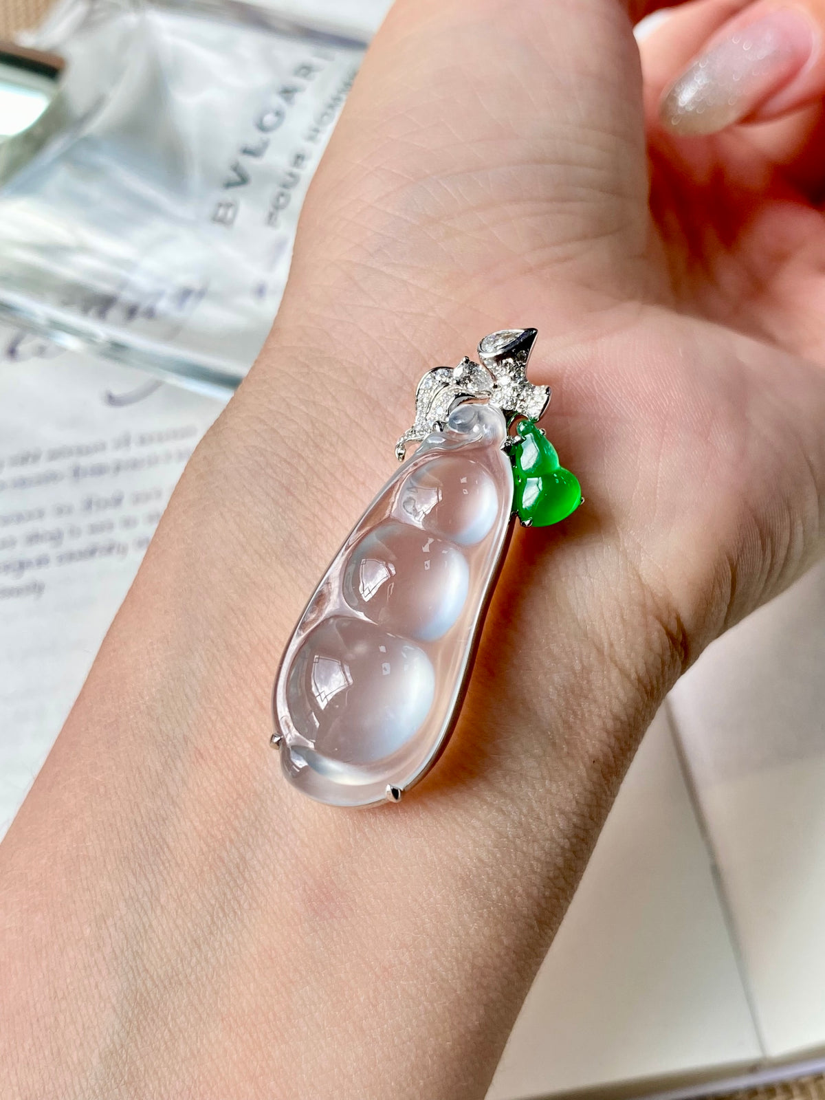 Hand-worn jadeite bean pendant: clear teardrop stone, diamond-like accents, green charm