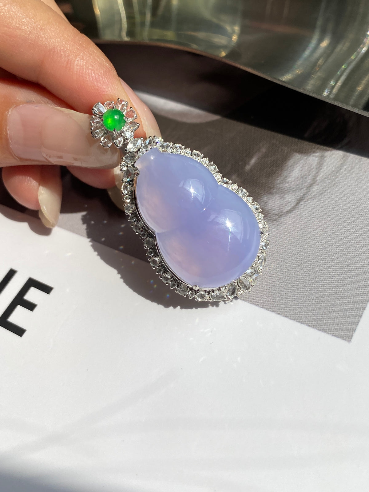 Lavender oval jadeite pendant with silver halo and green flower top
