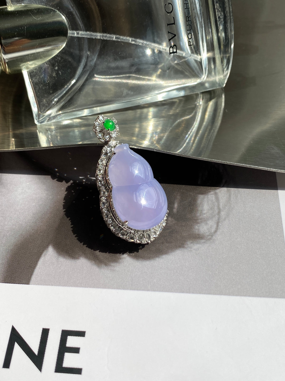 Lavender teardrop pendant with ornate silver frame and green flower accent