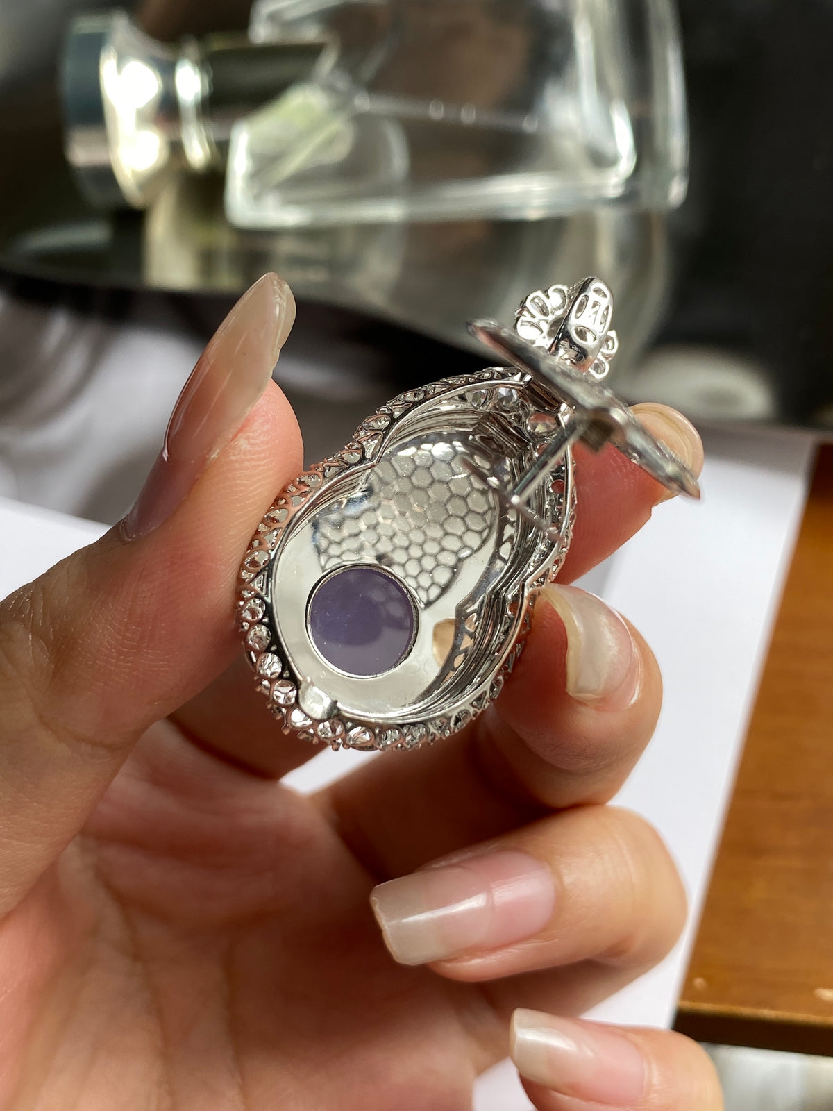 Silver back of teardrop pendant with purple center and textured guilloche rim