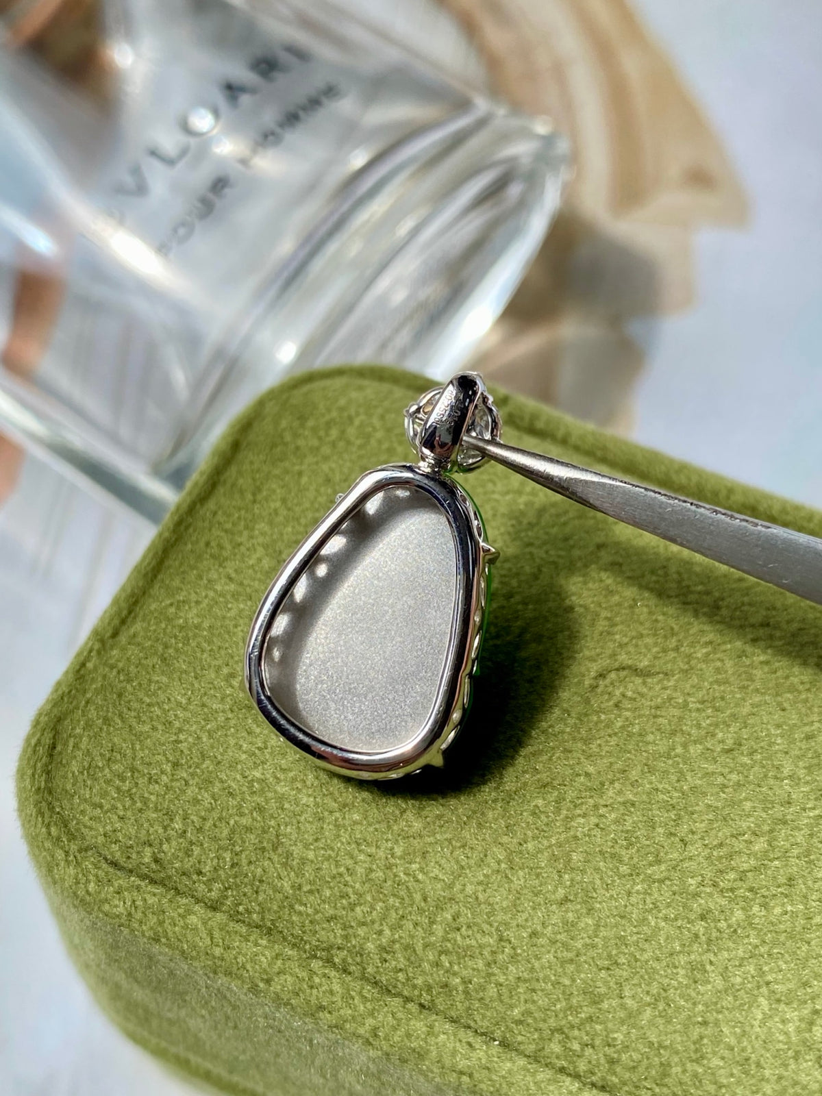 Silver teardrop pendant setting with textured rim and small diamond-like top stone