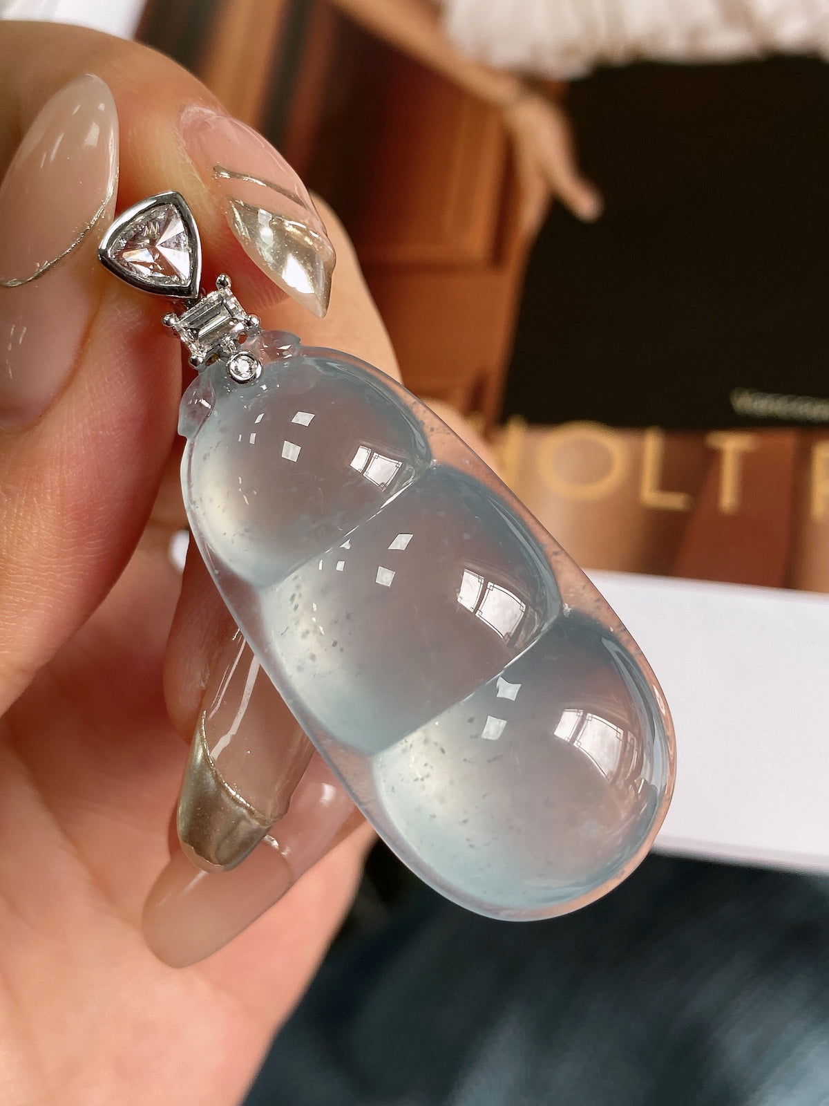 Sky-blue jadeite bean pendant with silver-tone bail, faceted oval stone