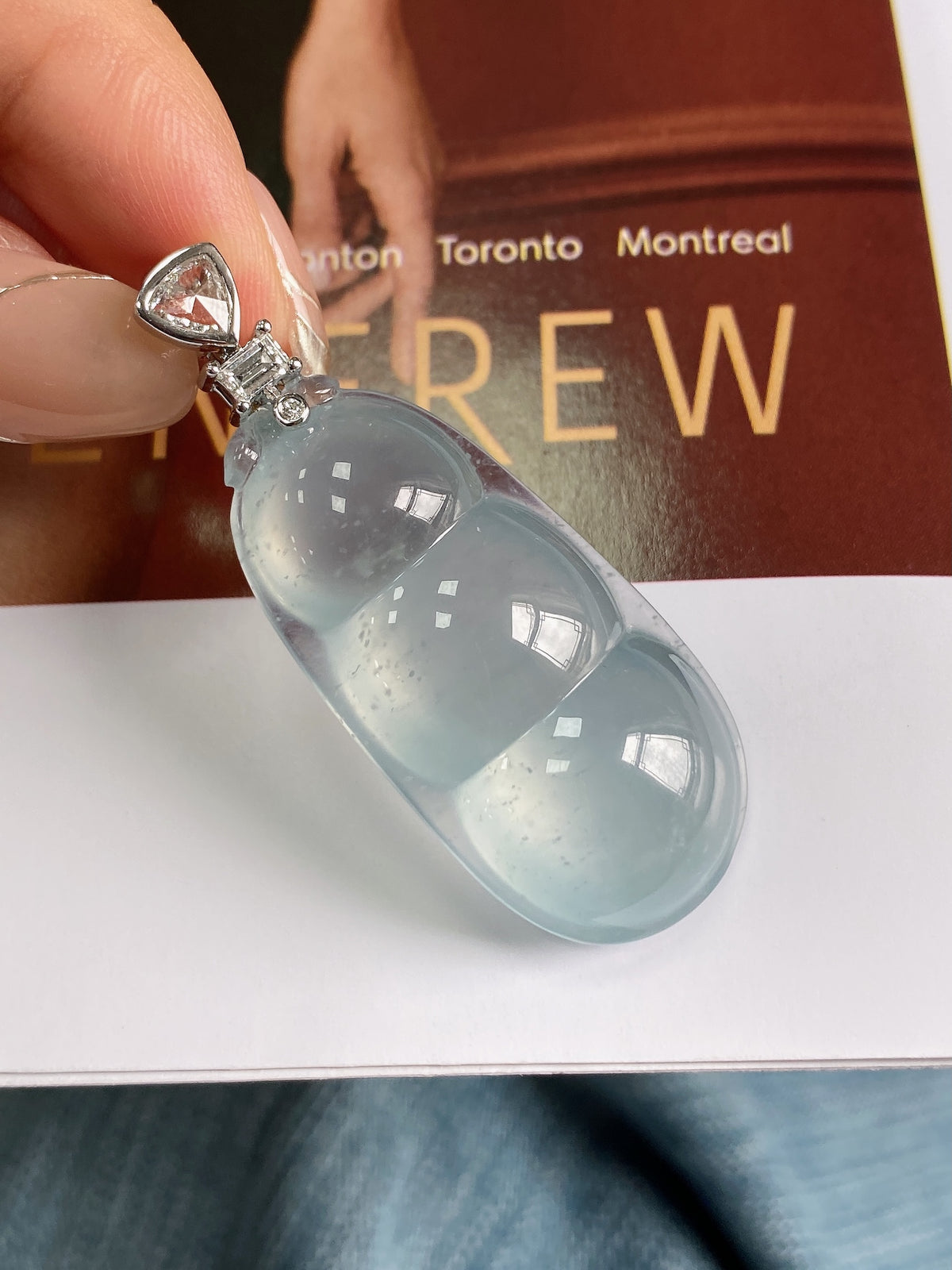 Sky-blue jadeite bean pendant, oval teardrop stone with silver-tone cap and bail