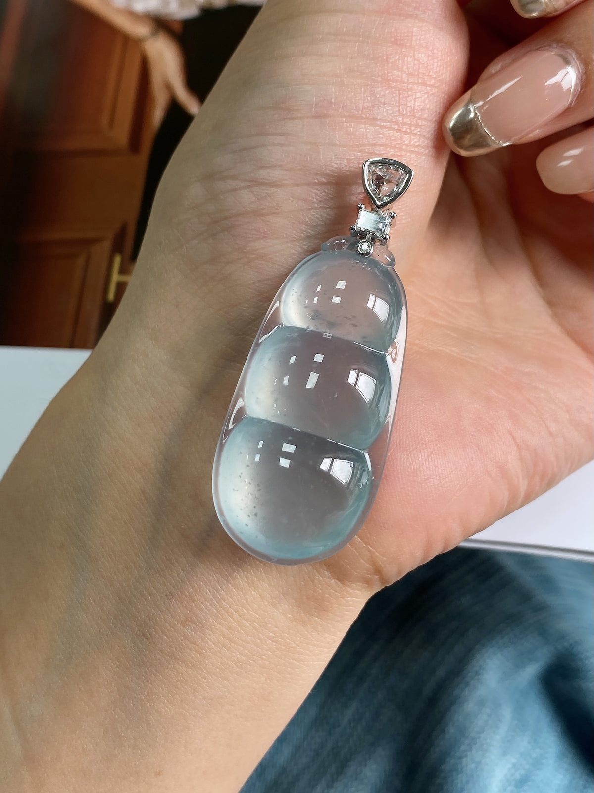 Sky-blue jadeite bean pendant on hand, oval stone with silver-tone top setting