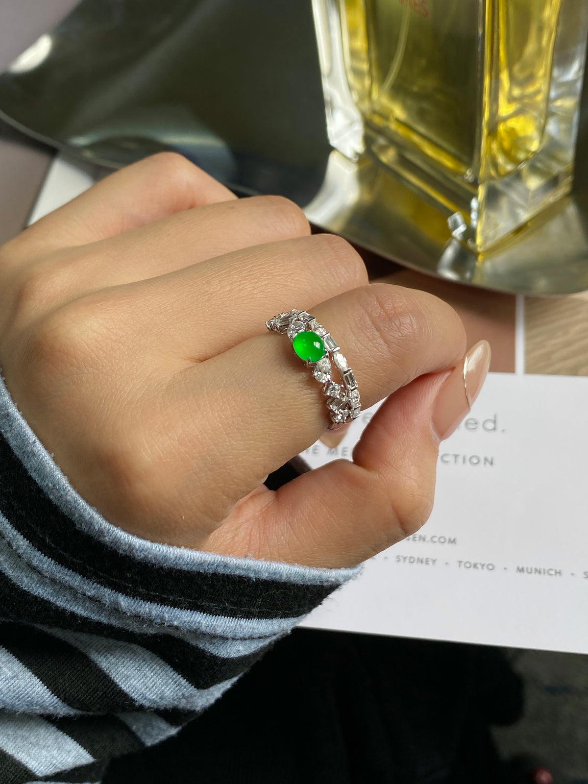 Stackable ring on finger with green cabochon and silver pave accents