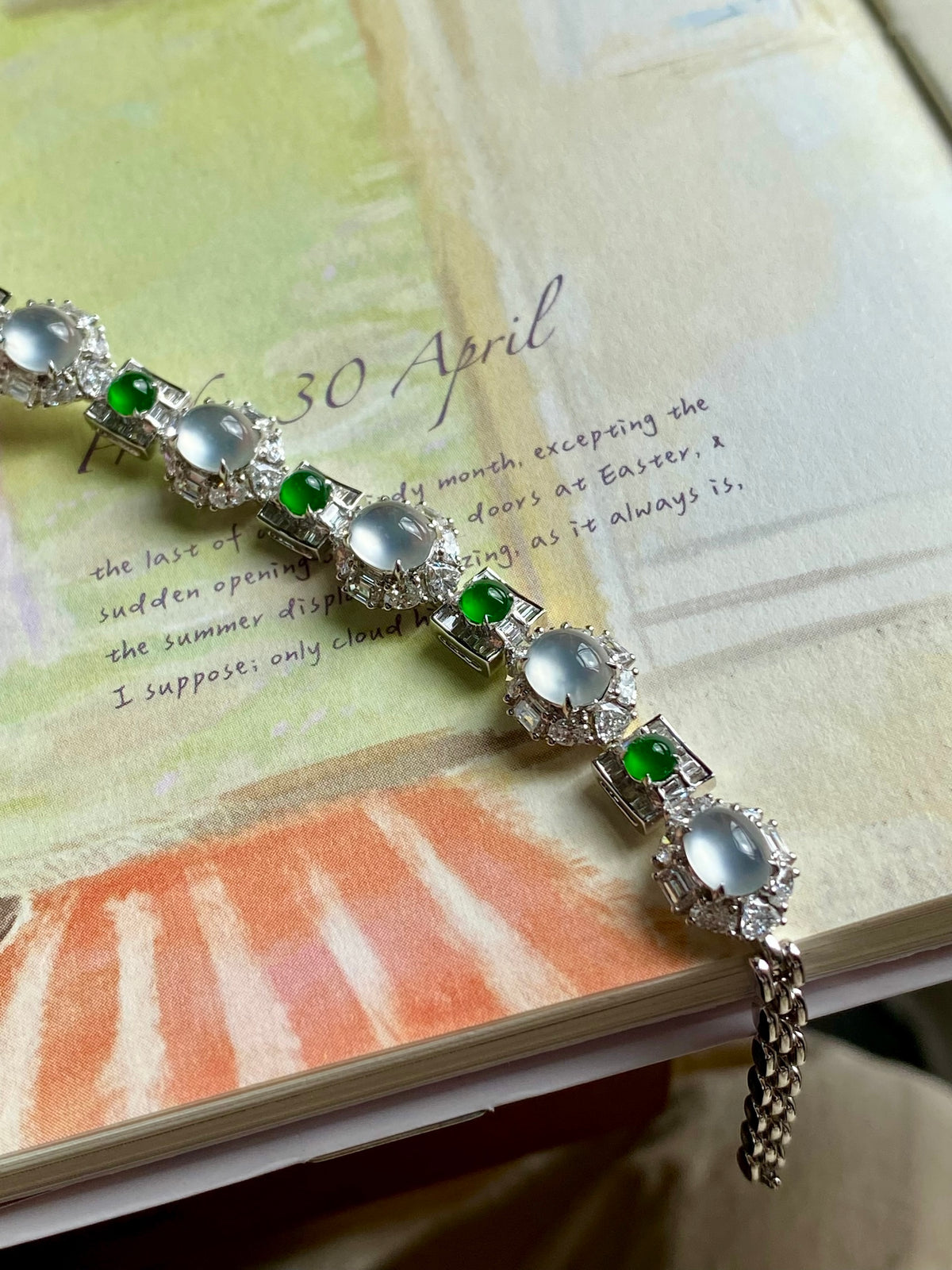 Jadeite cabochon bracelet laid flat, oval icy stones with small green gem highlights