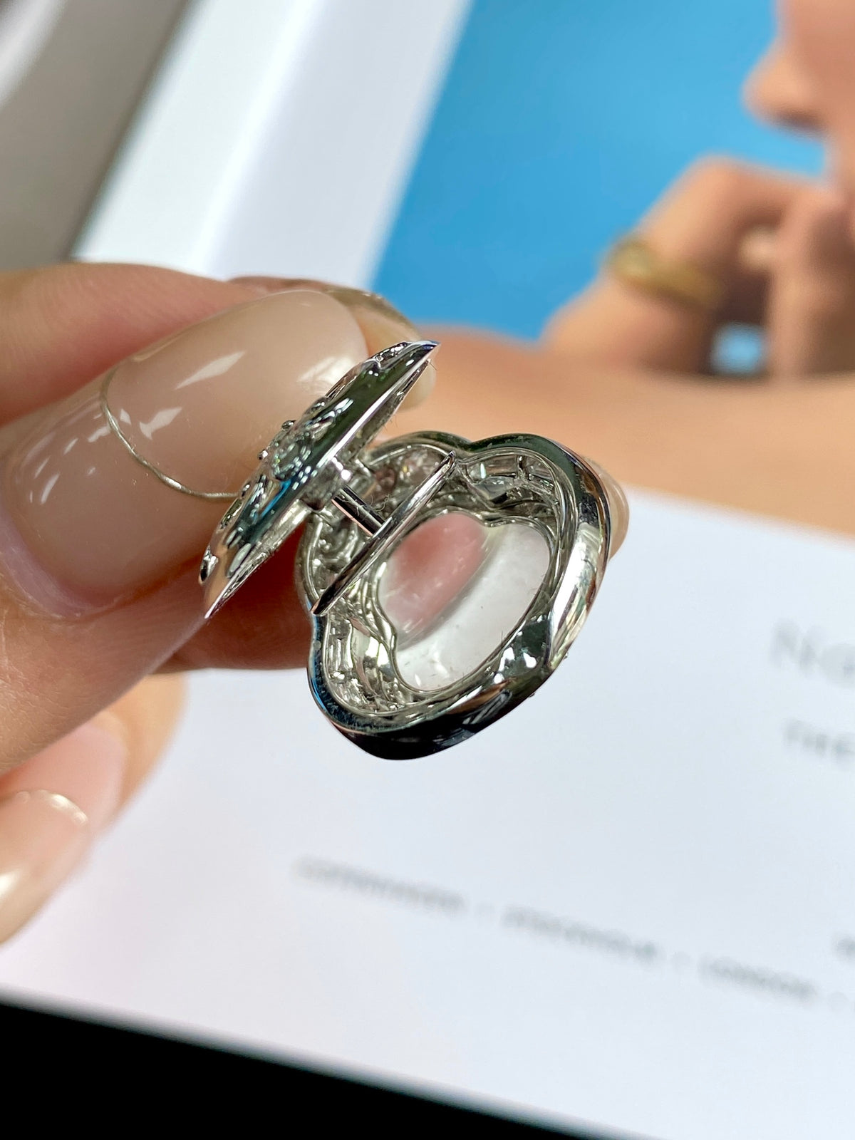 Silver pendant bale and bezel detail with oval light green stone, close-up