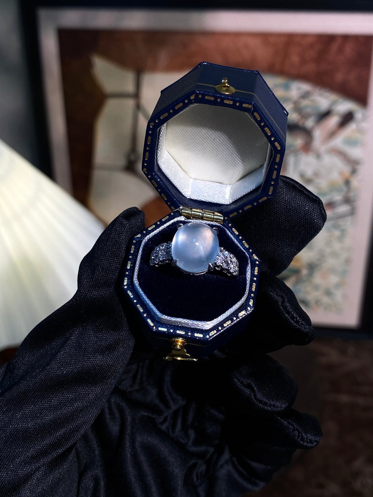 Light-blue oval cabochon ring with silver halo, shown in blue display box