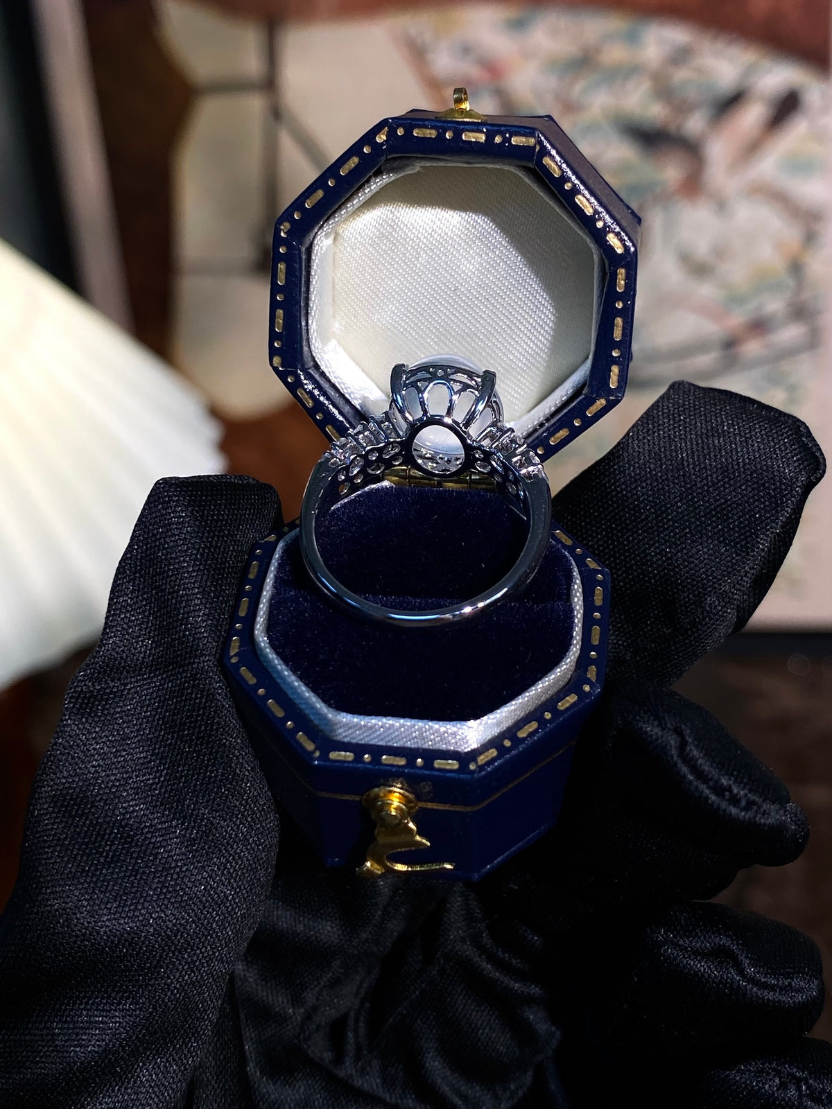 Round cabochon ring with light-blue center and cluster of crystal-like accents