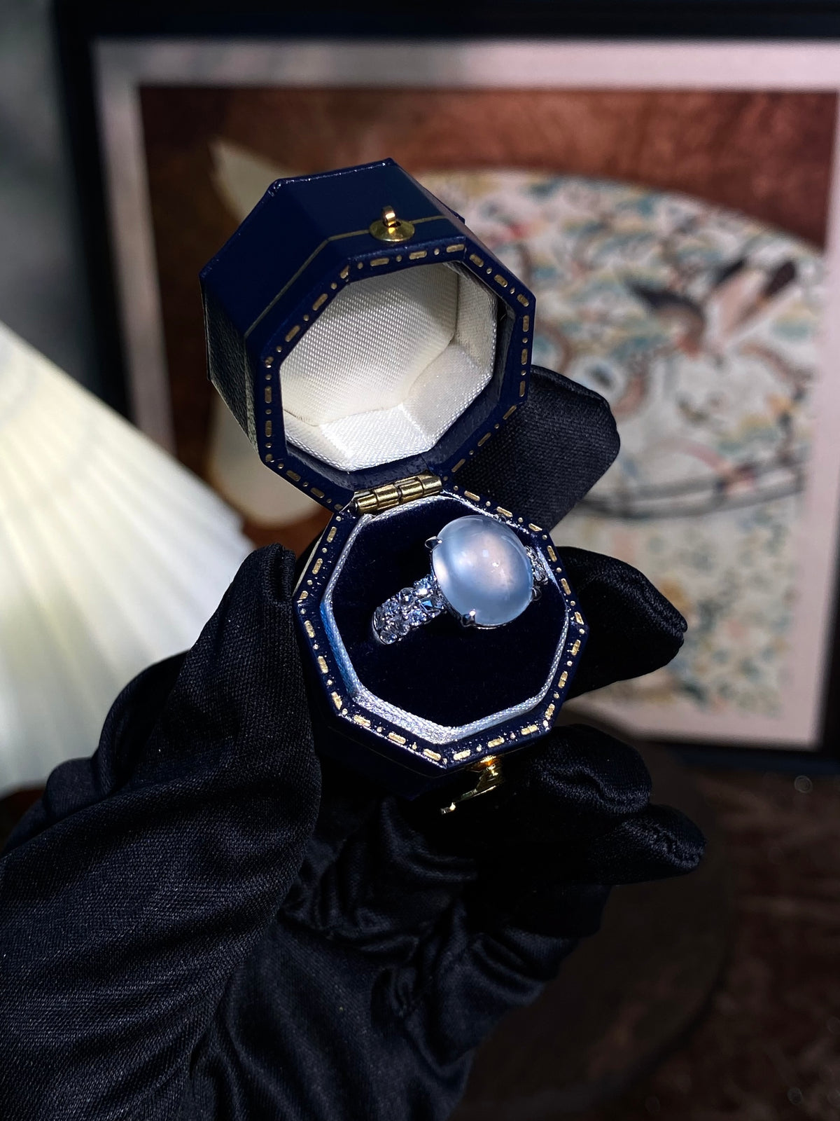 Light-blue oval cabochon ring with silver halo and prong-set stones