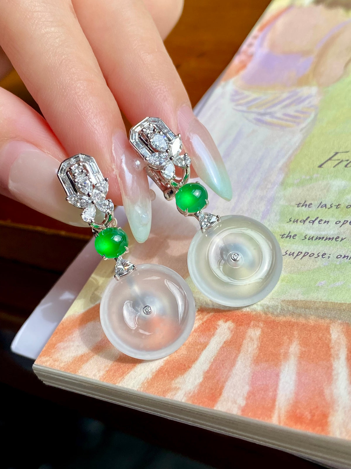 Pair of silver drop earrings with white donut discs, green beads, baguette crystal settings