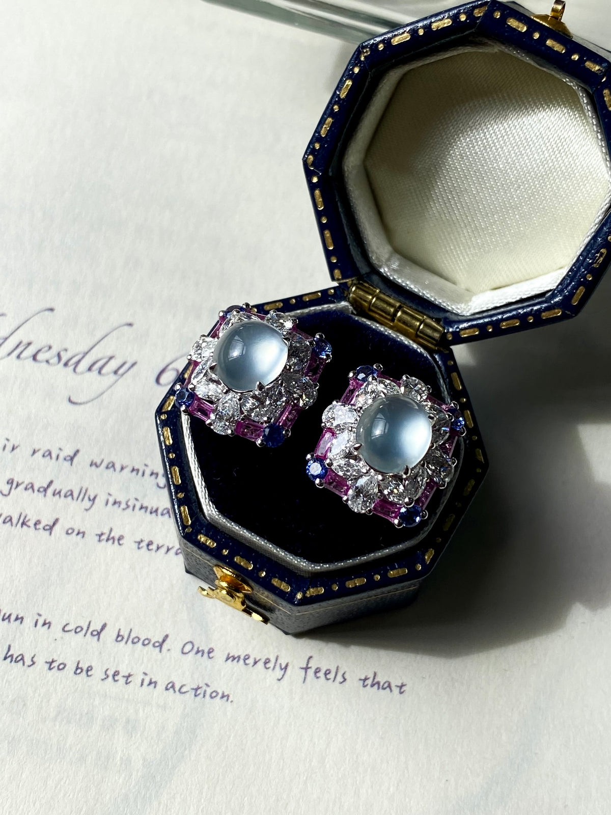 Stud earrings with light blue oval cabochon centers, purple crystal squares, silver posts