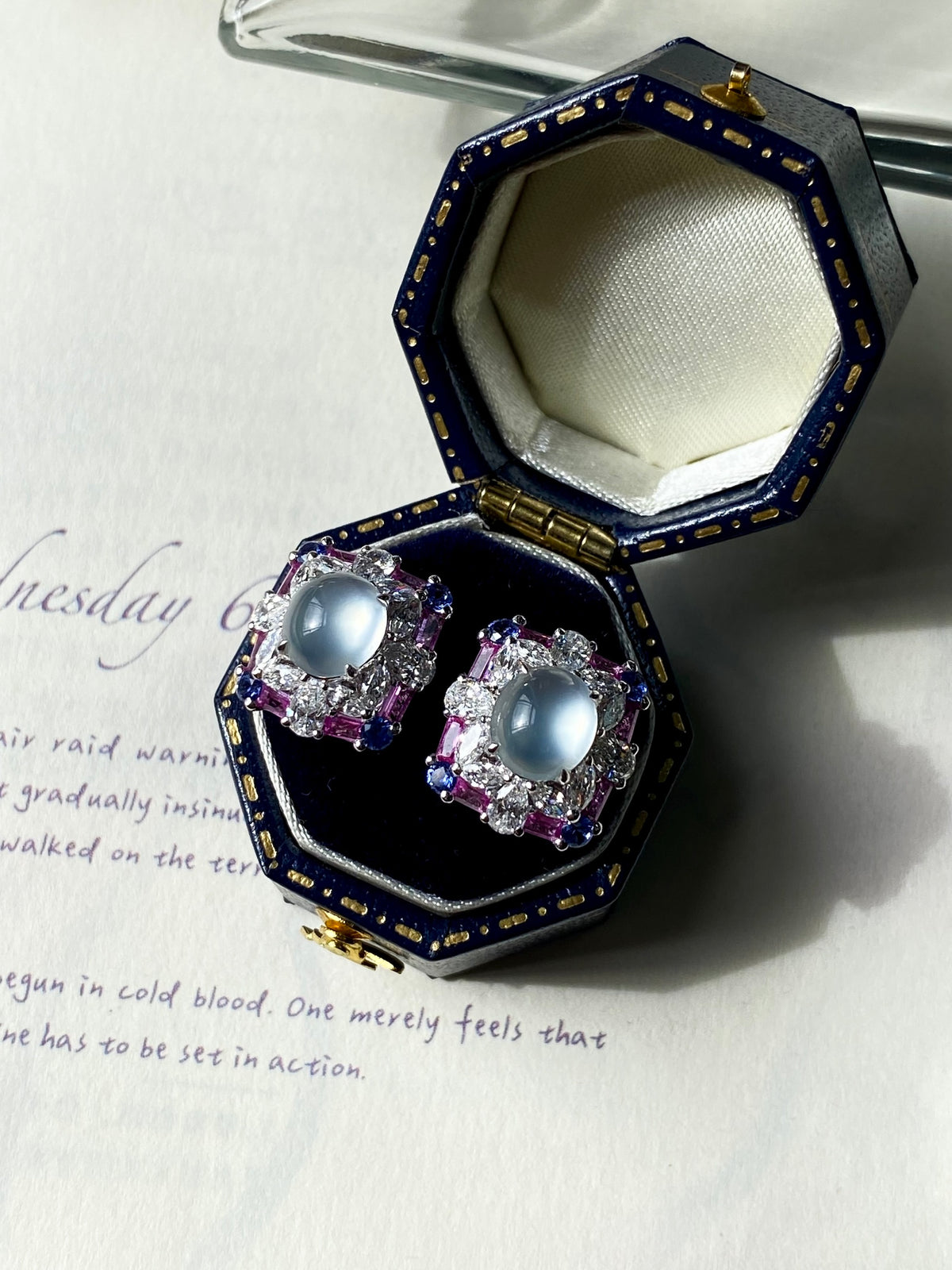 Jadeite cabochon stud earrings with light blue oval stones, purple accents, silver setting