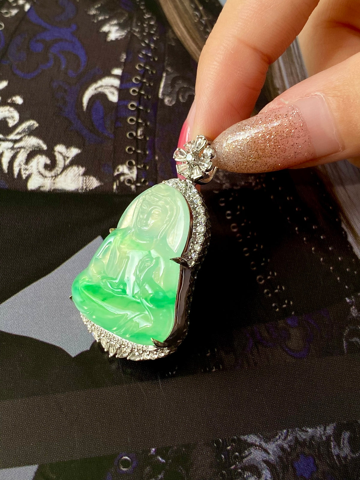 Green jade Guanyin heart pendant showing carved figure in ornate silver frame