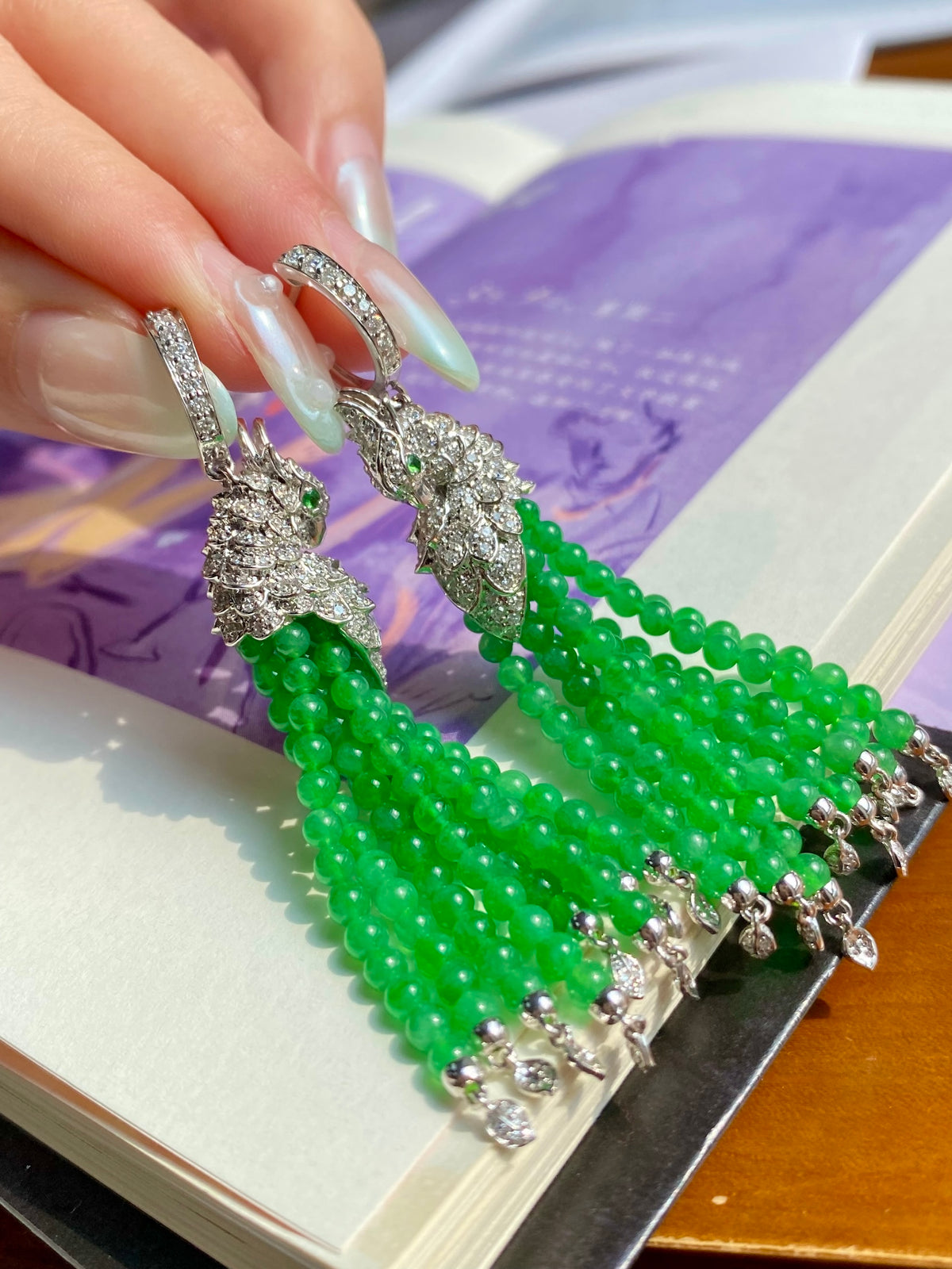 Silver-toned peacock drop earrings with long strands of bright green jade beads