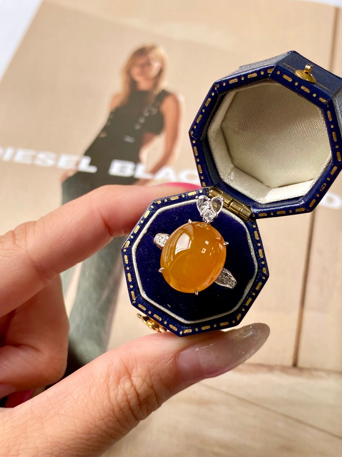 Amber cabochon ring pendant in navy blue octagonal case, open setting