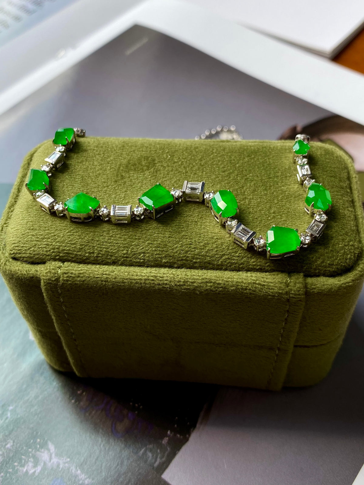 Green jadeite bead necklace with silver links and bright green gemstone accents