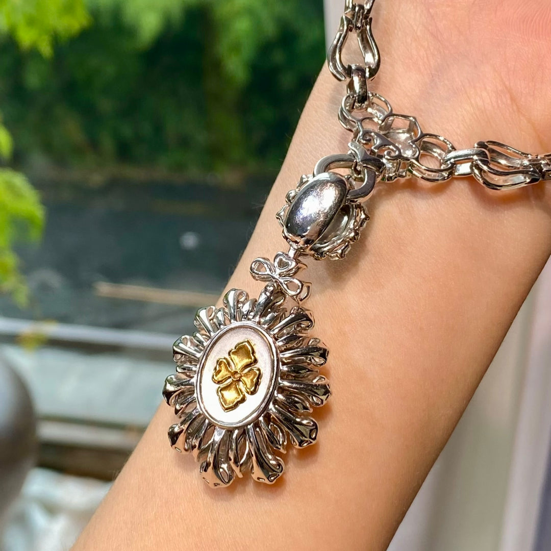 Silver-tone pendant necklace with green cabochon at center and ornate metal frame