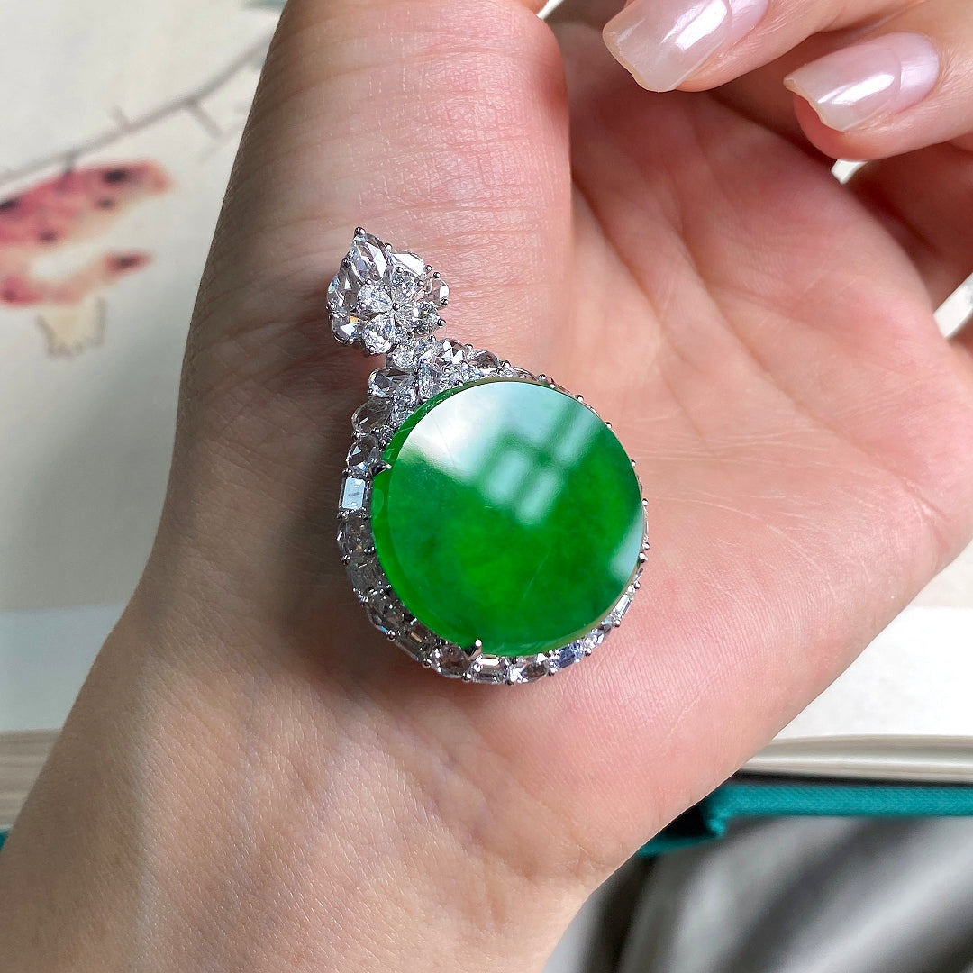 Green jadeite tablet pendant on silver-toned setting with prong-set clear stones