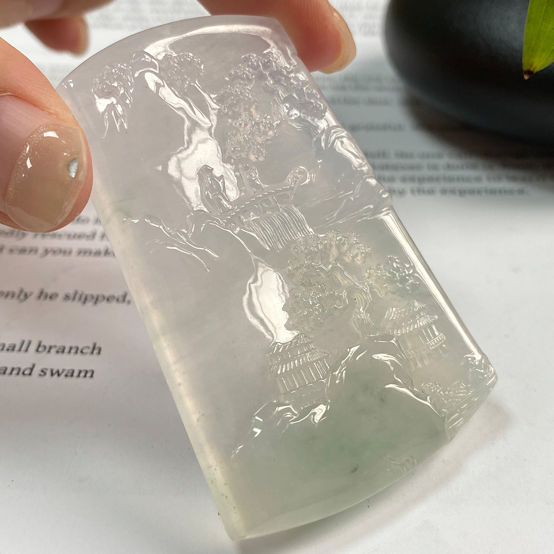 Jadeite landscape pendant with carved mountain-and-village motif on translucent bluish stone
