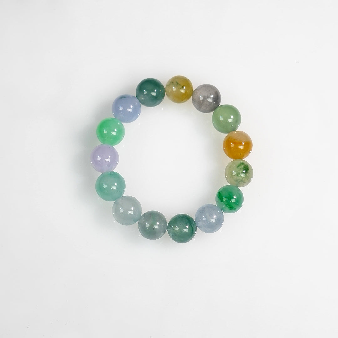 Multi-color jadeite beaded bracelet, flat lay of round green, blue, lavender, gray, and amber beads