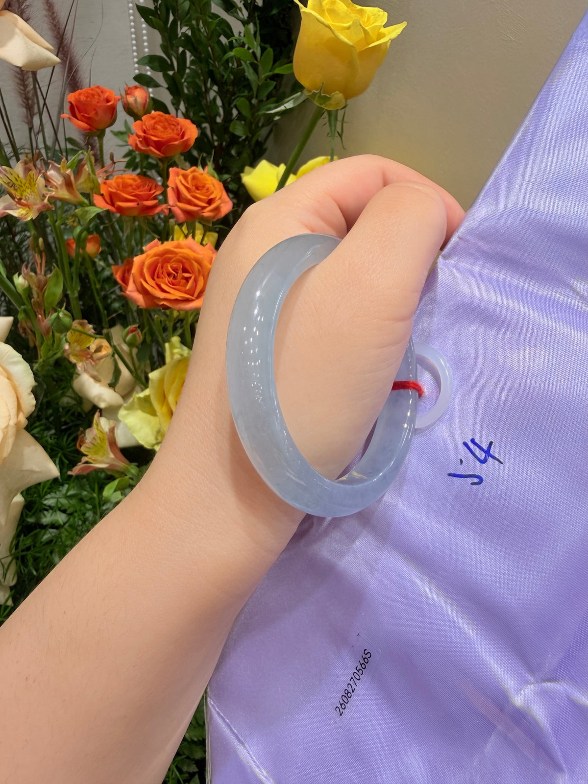 Light blue translucent bangle bracelet worn on wrist, smooth glossy texture.